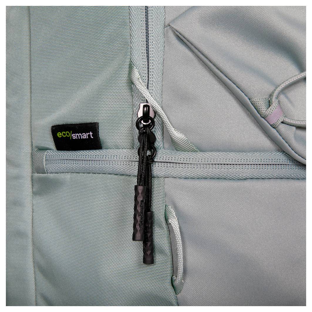 Eine Nahaufnahme eines hellgrauen Rucksacks mit einem 'eco smart' Etikett, einem schwarzen Reißverschluss mit zwei Ziehlaschetten und einem strukturierten Gewebematerial.