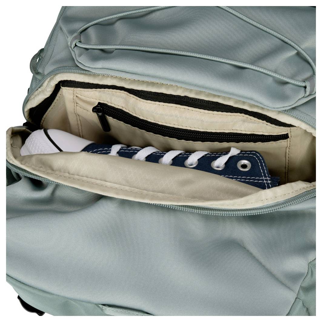 Ein hellblauer Rucksack ist geöffnet und zeigt das Innere der Tasche, in dem ein blauer Turnschuh mit weißen Schnürsenkeln liegt.