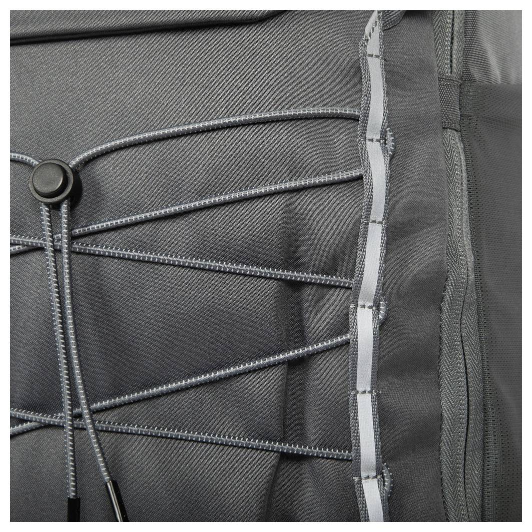 Nahaufnahme eines grauen Rucksacks, die das Befestigungsseil-System und die Reißverschlussdetails auf dem Stoff zeigt.