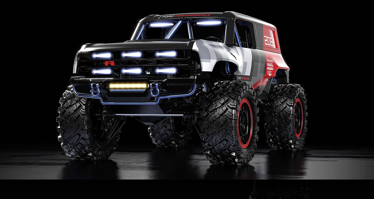 Ein großer, futuristischer Monstertruck mit überdimensionalen Reifen und hellen LED-Leuchten auf einer reflektierenden schwarzen Oberfläche.