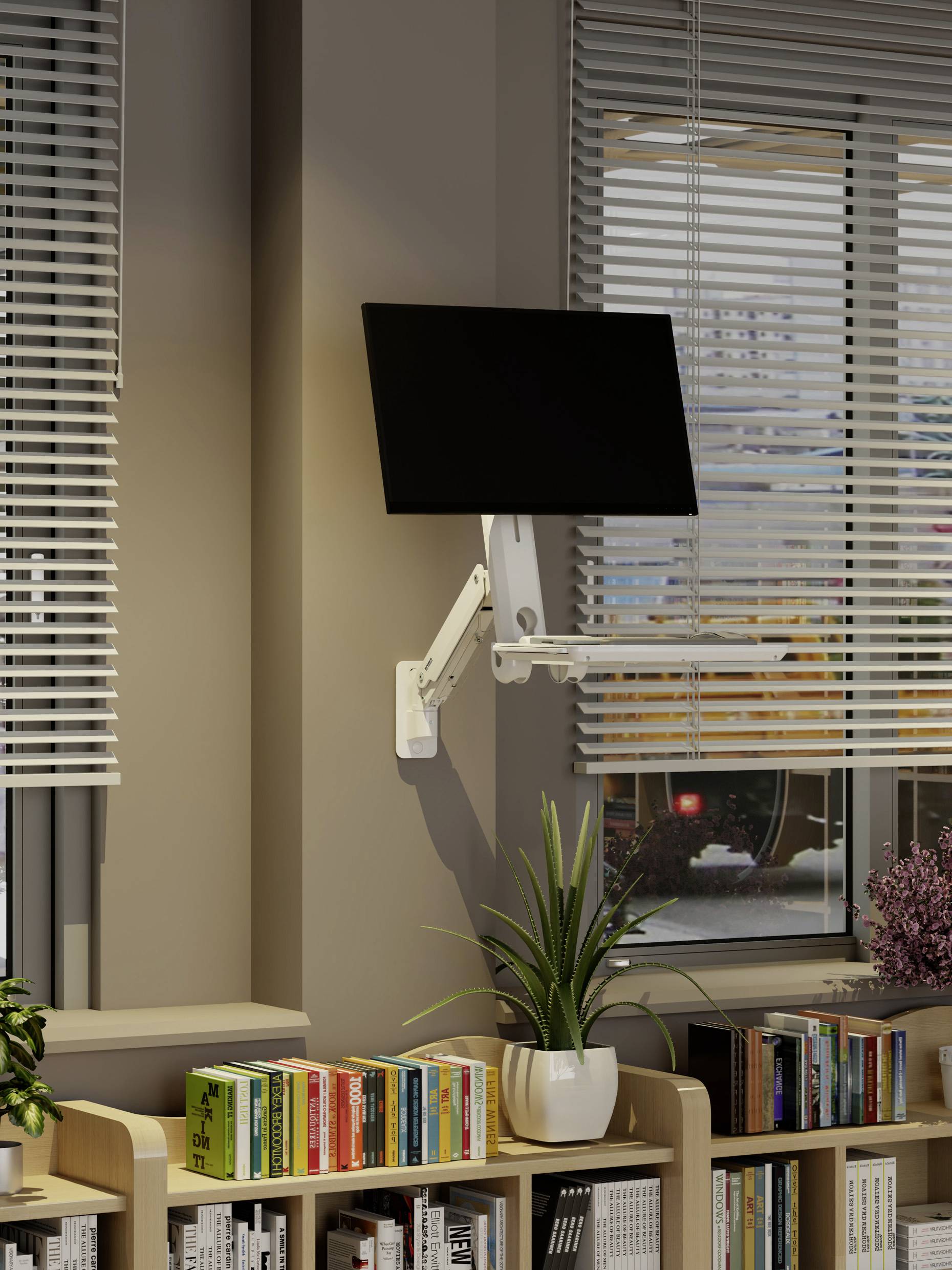 Ein Computermonitor ist an einem verstellbaren Arm befestigt, der an einer Wand über einem Bücherregal mit Büchern und Pflanzen montiert ist, neben einem Fenster mit Jalousien.