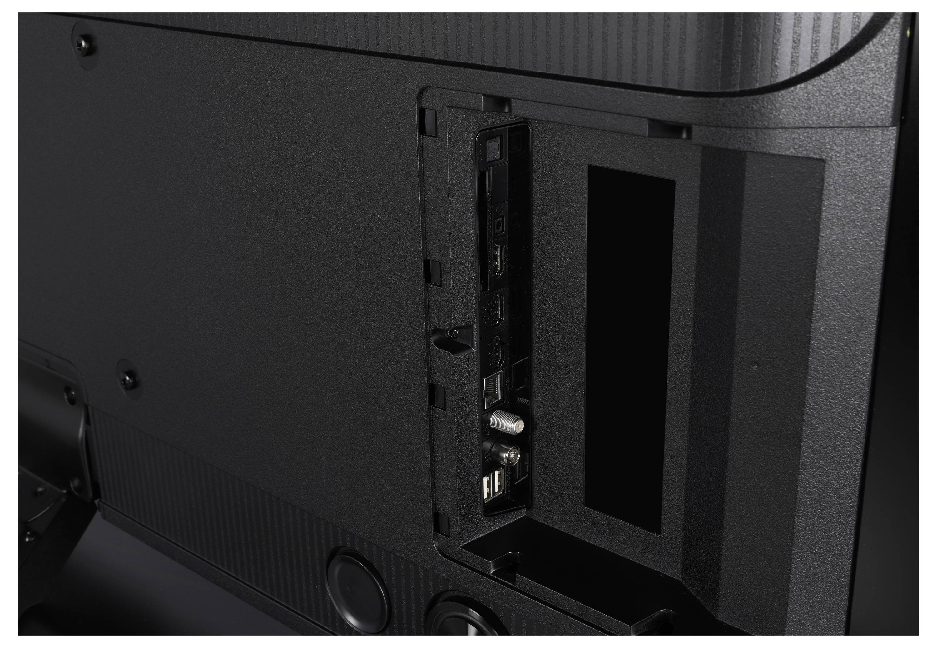 Rückansicht eines Fernsehers mit geöffnetem Panel, das mehrere Anschlüsse wie HDMI, USB und andere Konnektivitätseingänge zeigt.