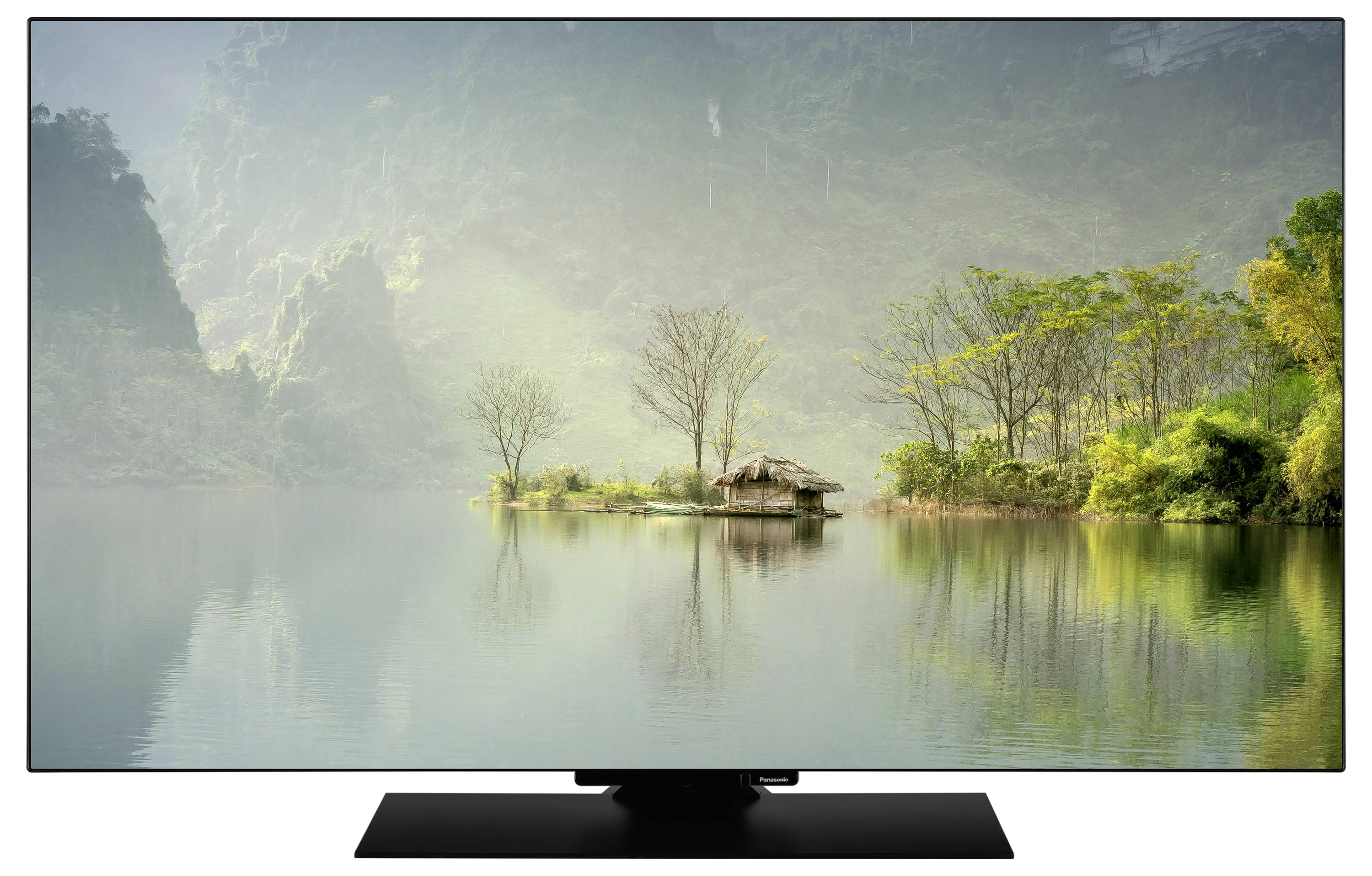 Eine Hütte auf einer kleinen Insel, umgeben von ruhigem Wasser und üppiger Vegetation, mit nebligen Hügeln im Hintergrund.