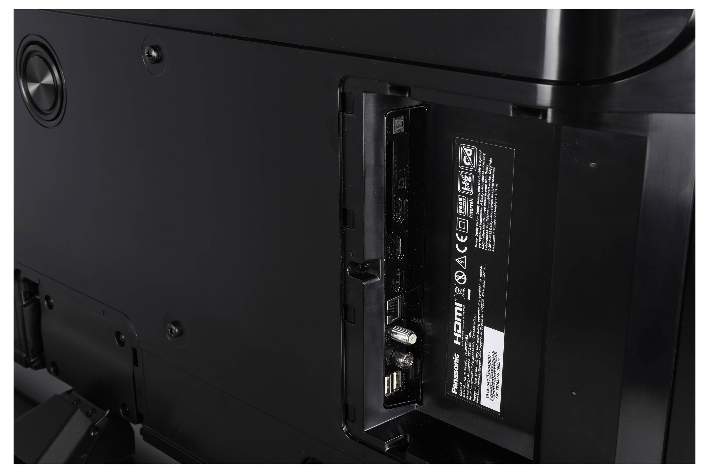 Rückseite eines Fernsehers mit Anschlüssen wie HDMI, USB und Koaxial, mit einer Beschriftung der Eingabemöglichkeiten.