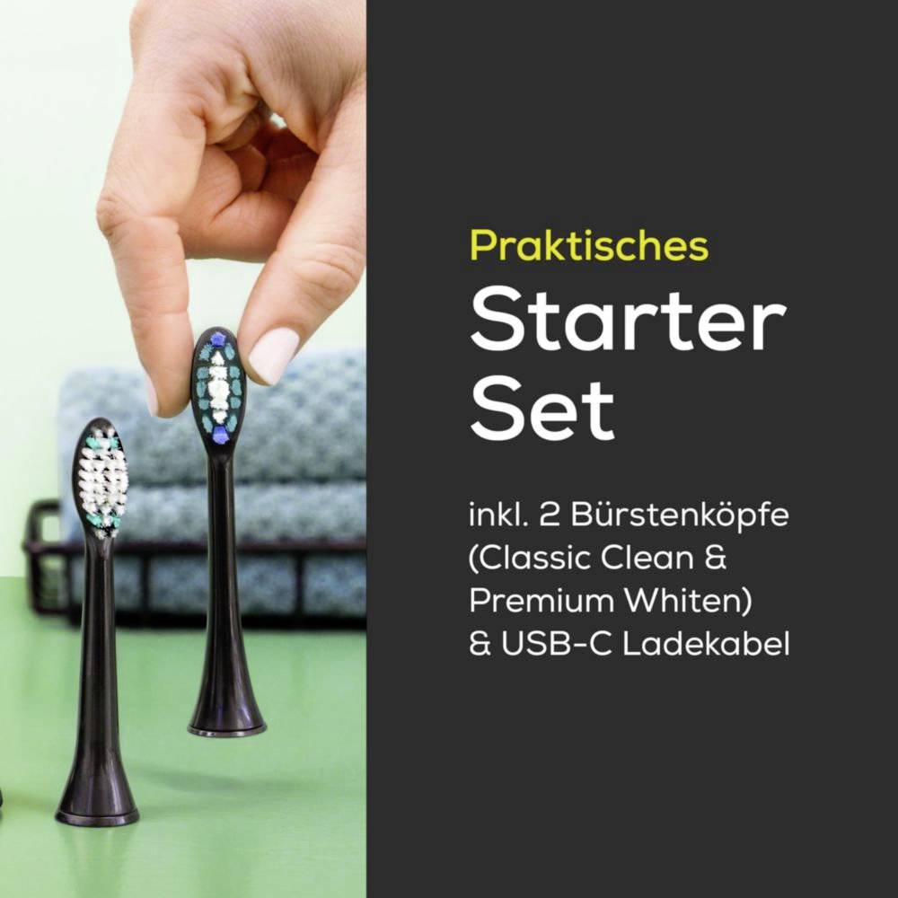A hand holds an electric toothbrush head with extra heads in the foreground. Text reads: 'Praktisches Starter-Set, inkl. 2 Bürstenköpfe & USB-C Ladekabel'.The text is already in German, so no translation is needed.