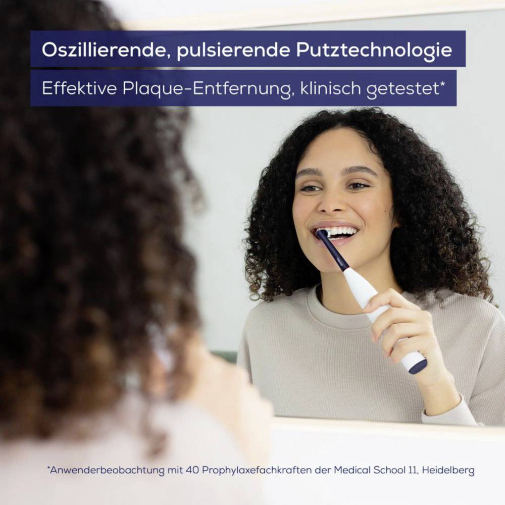 Eine Person putzt sich mit einer elektrischen Zahnbürste vor einem Spiegel die Zähne. Text lautet: 'Oszillierende, pulsierende Reinigungstechnologie. Effektive Plaqueentfernung, klinisch getestet.'