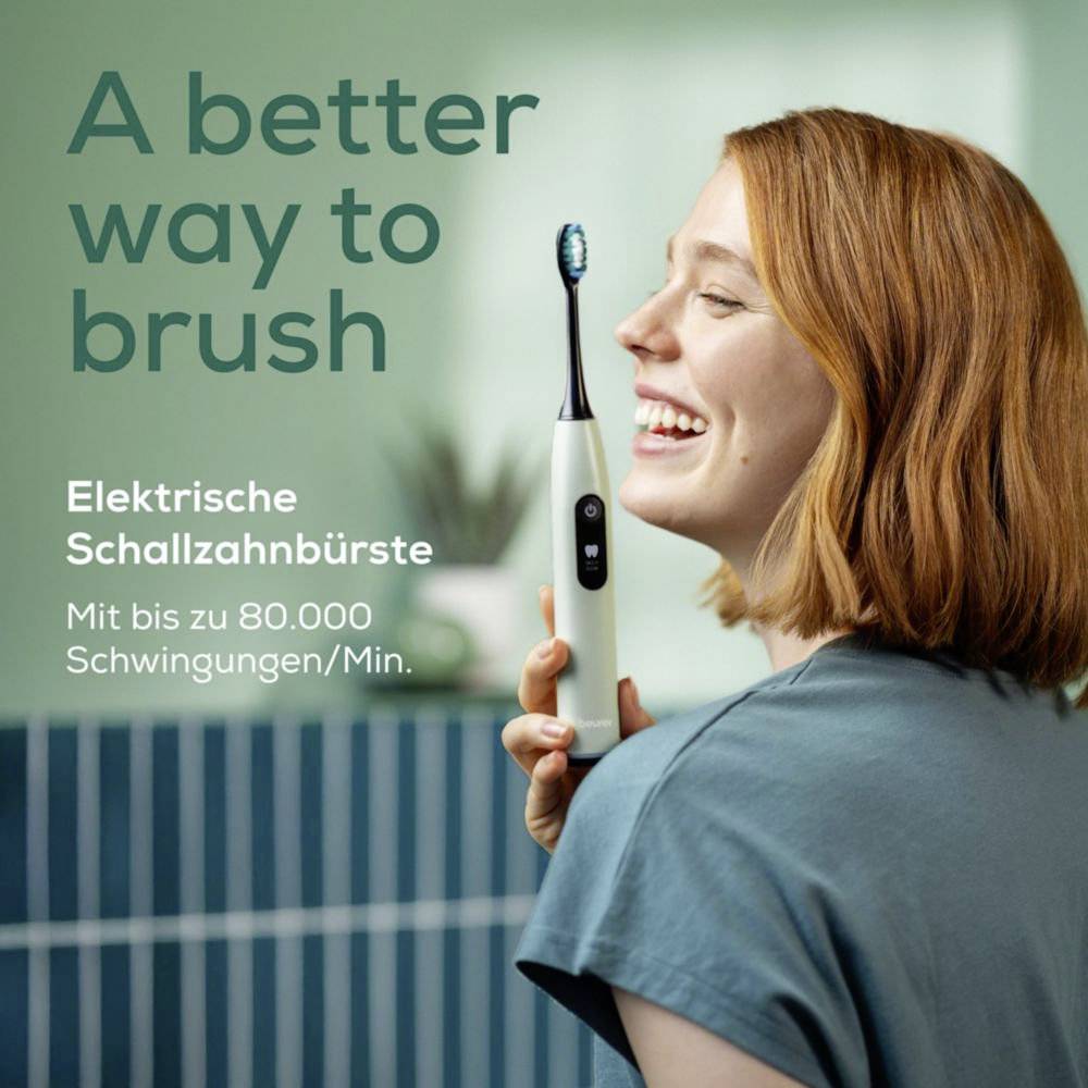 Eine Frau, die eine elektrische Zahnbürste hält, lächelt. Text lautet: 'Ein besserer Weg zum Zähneputzen. Elektrische Schallzahnbürste. Mit bis zu 80.000 Schwingungen/Min.'