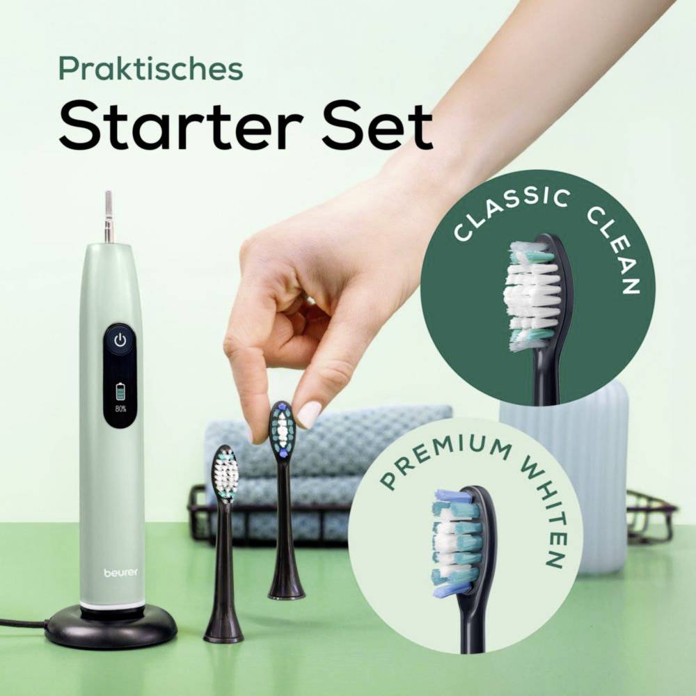 Eine Hand berührt auswechselbare Zahnbürstenaufsätze neben einer elektrischen Zahnbürste. Der Text liest sich 