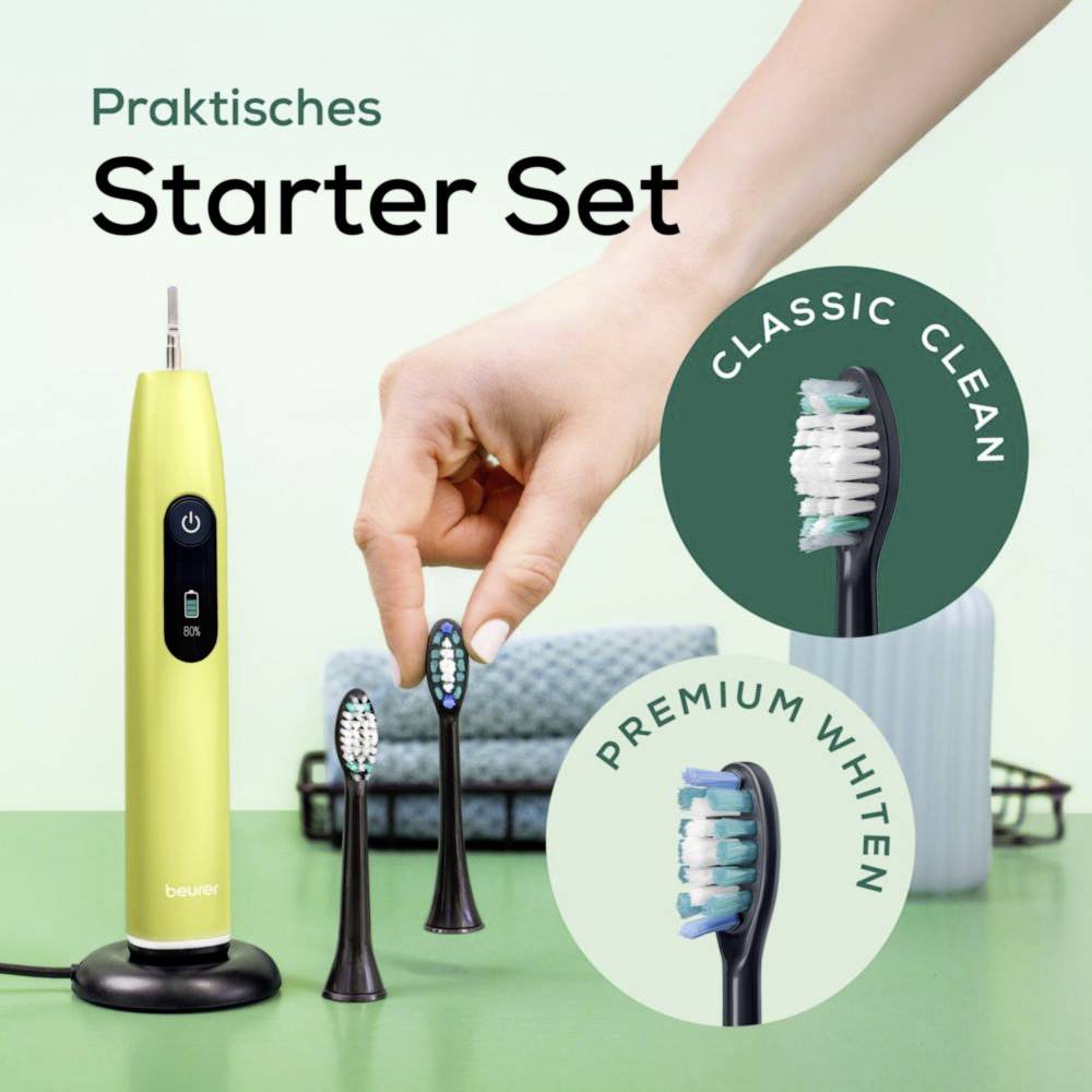Ein grüner elektrischer Zahnbürste mit drei zusätzlichen Aufsteckbürsten, beschriftet mit 'Classic Clean' und 'Premium Whiten', unter dem Text 'Praktisches Starter Set.'