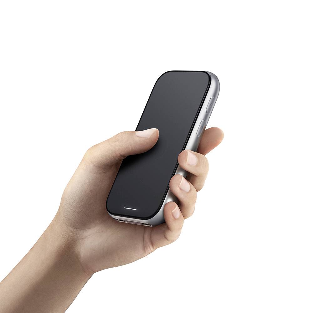 Eine Hand hält ein schwarzes Smartphone mit einem einfarbigen schwarzen Bildschirm vor einem weißen Hintergrund.