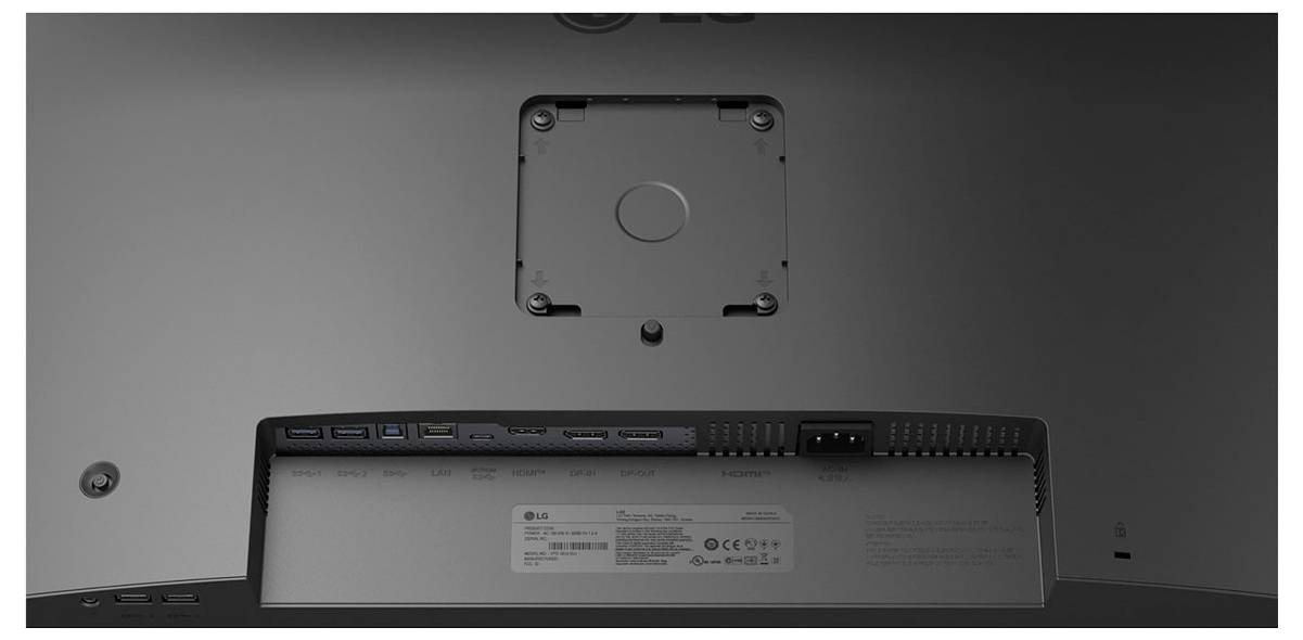 Das Bild zeigt die Rückseite eines Monitors mit VESA-Halterung, Netzteilanschluss, mehreren USB-Anschlüssen und einem Etikett mit Modell- und Produktinformationen.