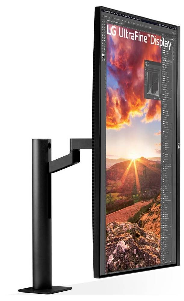 Ein vertikaler LG UltraFine Display-Monitor, der lebendige Landschaftsaufnahmen eines Sonnenuntergangs über Hügeln zeigt, montiert auf einem schwarzen Ständer.