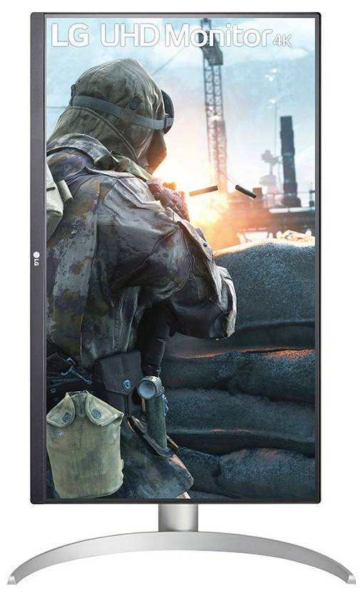 Ein Soldat in Ausrüstung ist auf dem Bildschirm eines vertikalen LG UHD-Monitors 4K zu sehen, der hinter einer Barriere steht, während im Hintergrund eine feurige Explosion zu sehen ist.