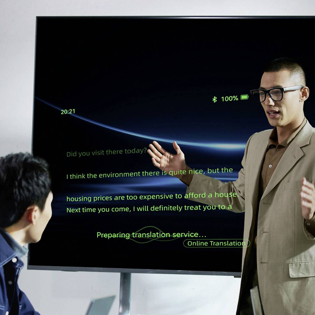 Ein Mann im Anzug gestikuliert vor einer Präsentationsleinwand, die Text, Icons und Grafiken zu Online-Übersetzungsdiensten zeigt.