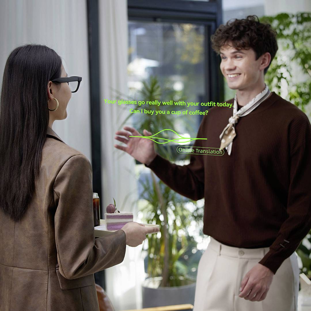 Ein Mann und eine Frau unterhalten sich in Innenräumen. Er zeigt auf sie und hält zwei Kaffeebecher. Text oben lautet: „Du solltest uns einen Kaffee kaufen?