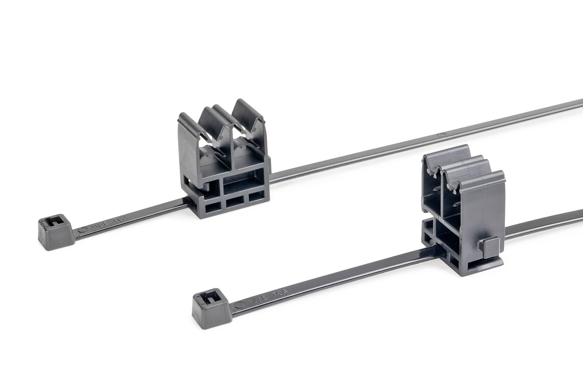 Zwei schwarze Kabelklemmen mit Verschlussmechanismus, konzipiert zur Sicherung von Kabeln. Jede verfügt über eine Montagebasis und einen integrierten Befestigungsriemen.