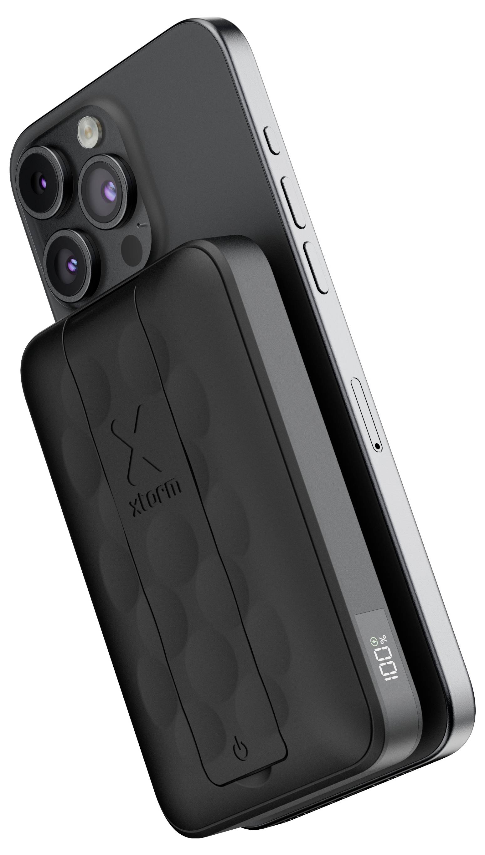 Eine schwarze Powerbank, die magnetisch an der Rückseite eines grauen Smartphones befestigt ist und einen '100%' Ladezustand auf einem kleinen Display der Powerbank anzeigt.