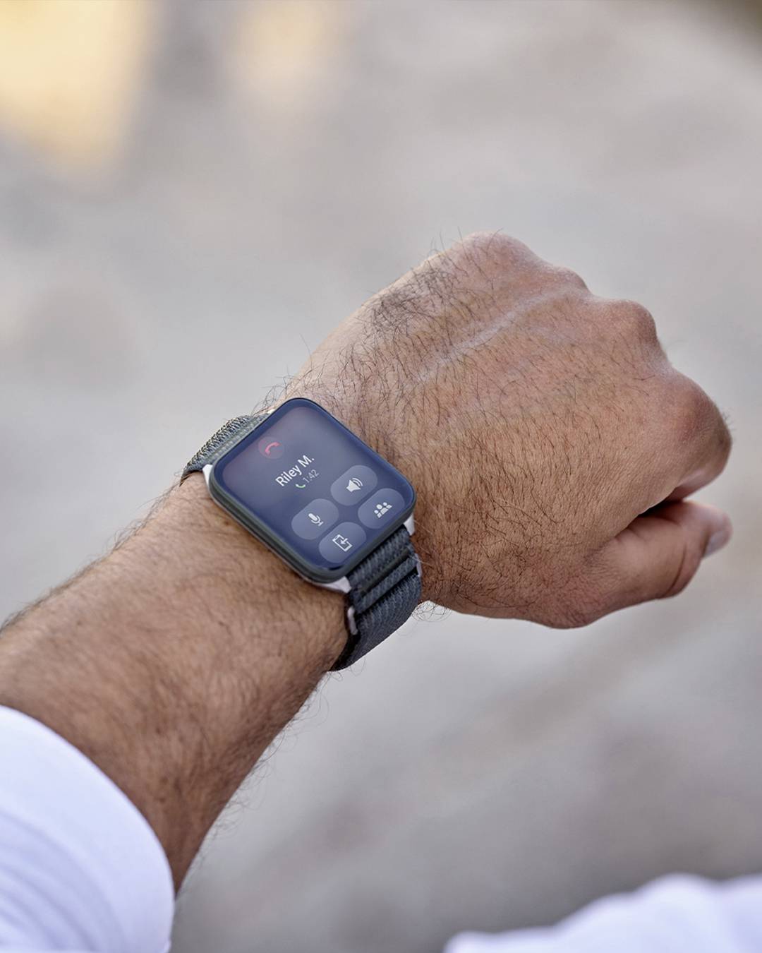 Eine Person im Freien, die eine Smartwatch trägt, auf der ein eingehender Anruf mit den Optionen 