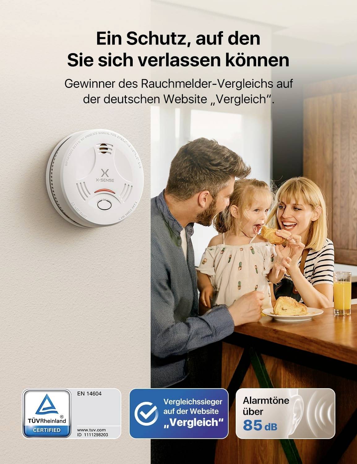 Familie in Küche neben Rauchmelder, der von deutscher Vergleichsseite als Testsieger ausgezeichnet wurde; Alarm über 85 dB.