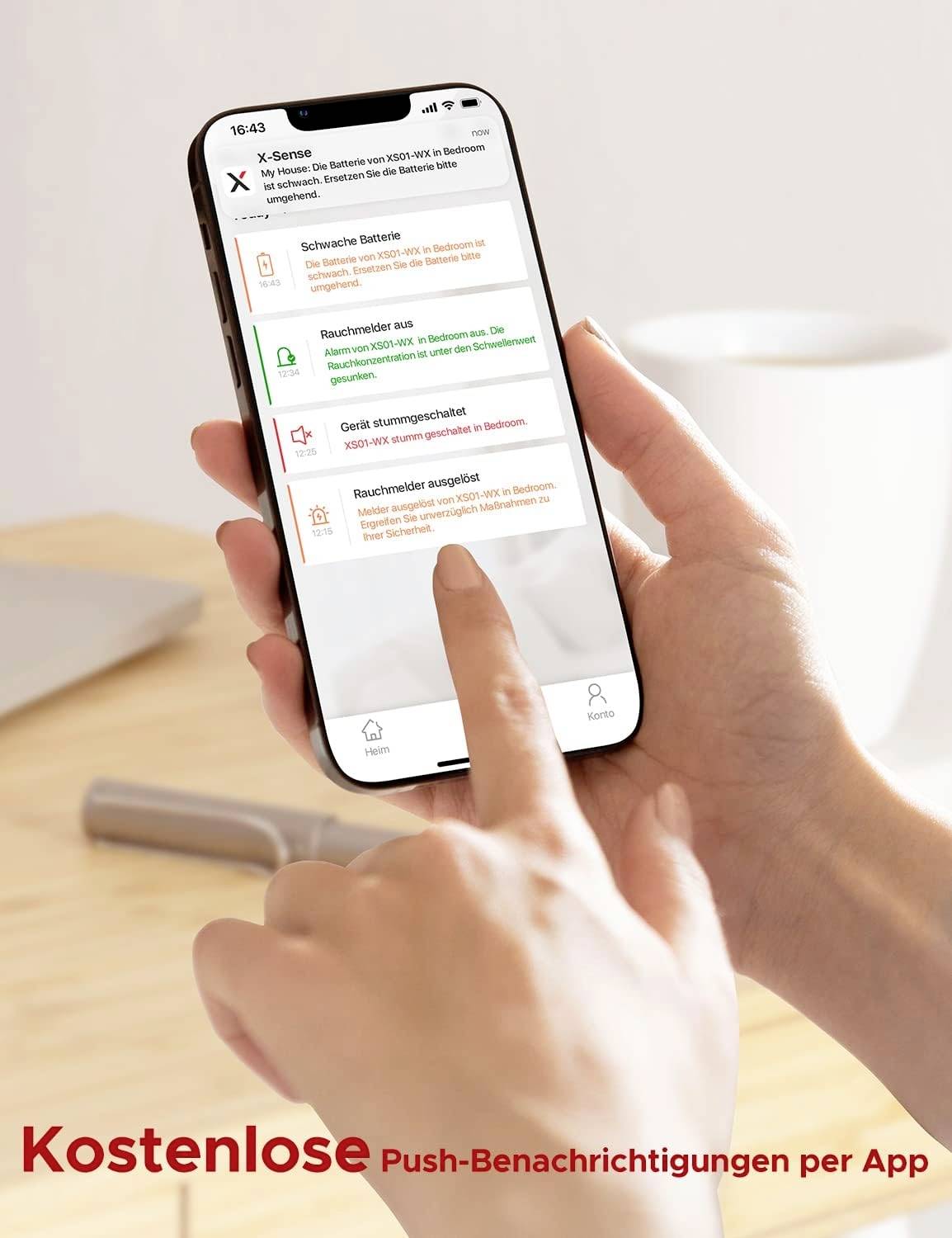 Hand hält Smartphone mit App zur Rauchmelder-Warnung. Bildschirm zeigt Benachrichtigungen zu Batterie, Sensorstatus und Alarmen. Hintergrund unscharf.