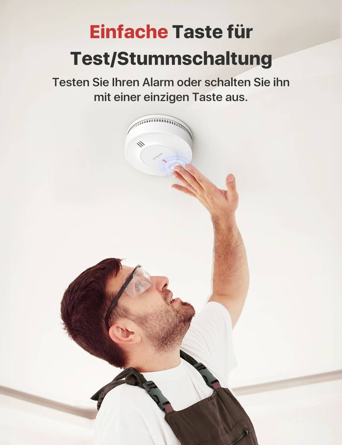 Ein Mann drückt die Testtaste eines Rauchmelders an der Decke. Der Text lautet: 'Einfache Taste für Test/Stummschaltung'.