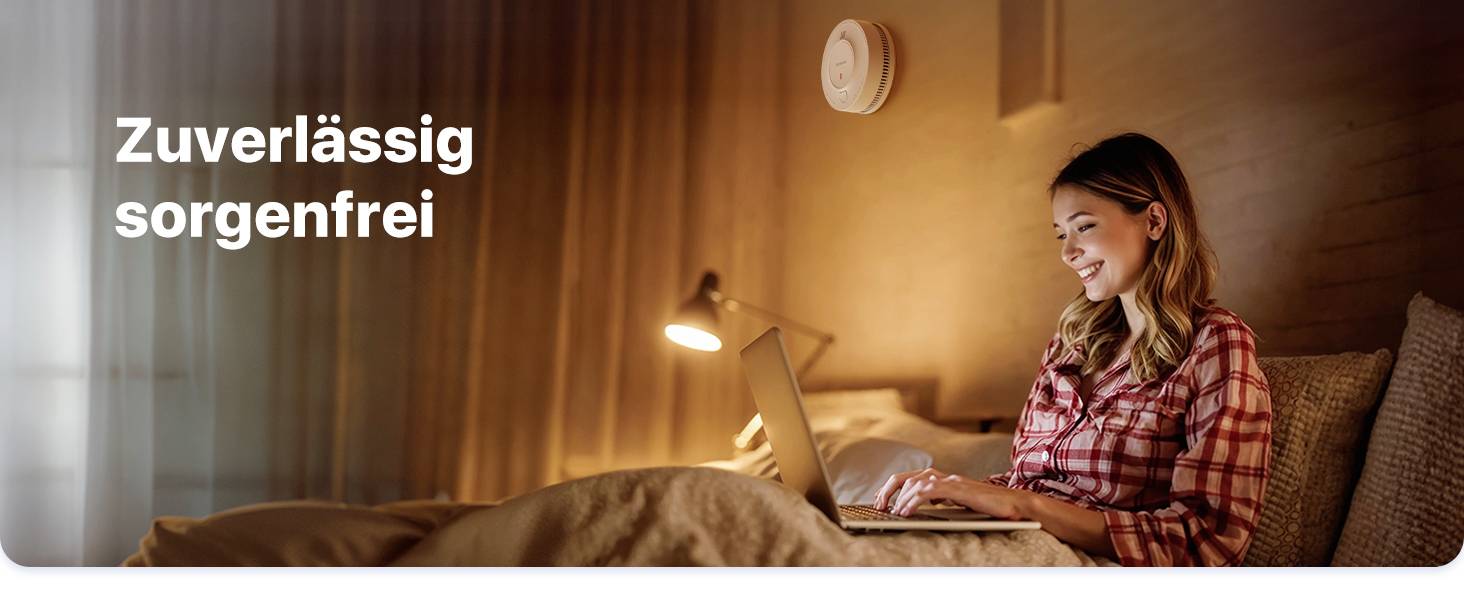 Eine lächelnde Frau sitzt auf einem Bett und benutzt einen Laptop. Links steht der Text 'Zuverlässig sorgenfrei'.