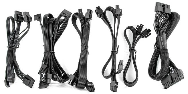 Eine Sammlung verschiedener schwarzer Netzkabel, vertikal angeordnet, jedes mit unterschiedlichen Anschlüssen, wahrscheinlich für Computer-Hardware verwendet.