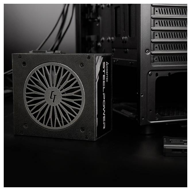 Netzteil eines Computers mit der Bezeichnung SteelPower neben einem PC-Gehäuse, wobei das schwarze Design und die sichtbare Lüftergitterstruktur hervorgehoben werden.