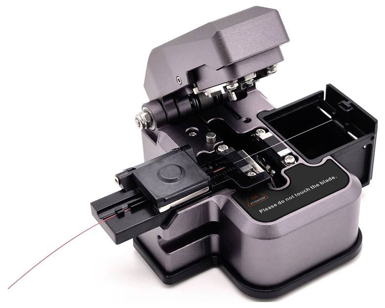 Ein Glasfaserschneider mit montiertem Kabel und offenem Klingenkompartiment, verwendet zur präzisen Durchtrennung von optischen Fasern.