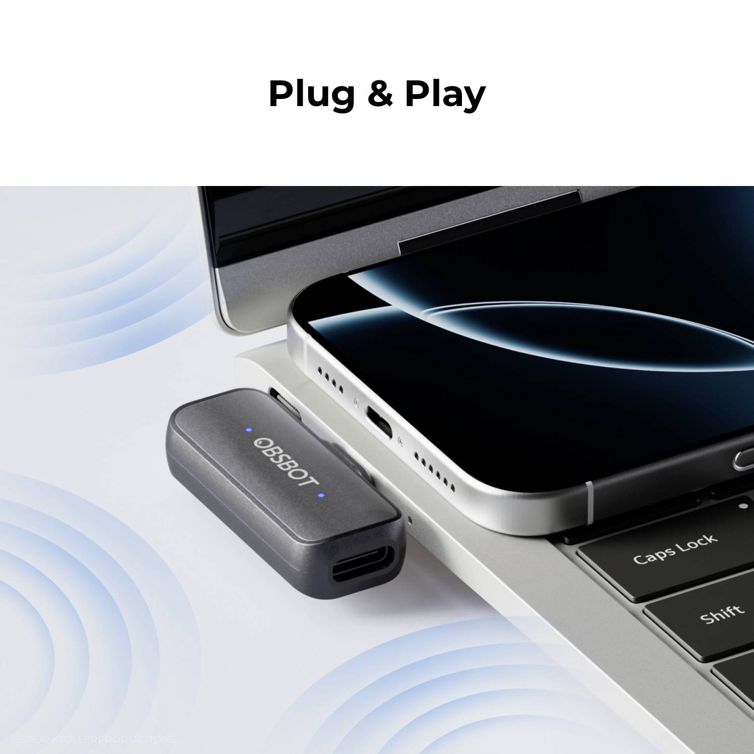 Ein Smartphone, das auf einer Laptop-Tastatur liegt, mit einem kleinen Gerät in der Nähe; der Text lautet 