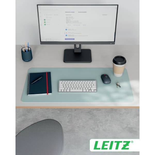 Ein aufgeräumter Schreibtisch mit einem Monitor, der eine Website anzeigt, einer Tastatur, einer Maus, einem Notizbuch und einer Tasse Kaffee. Das Logo 