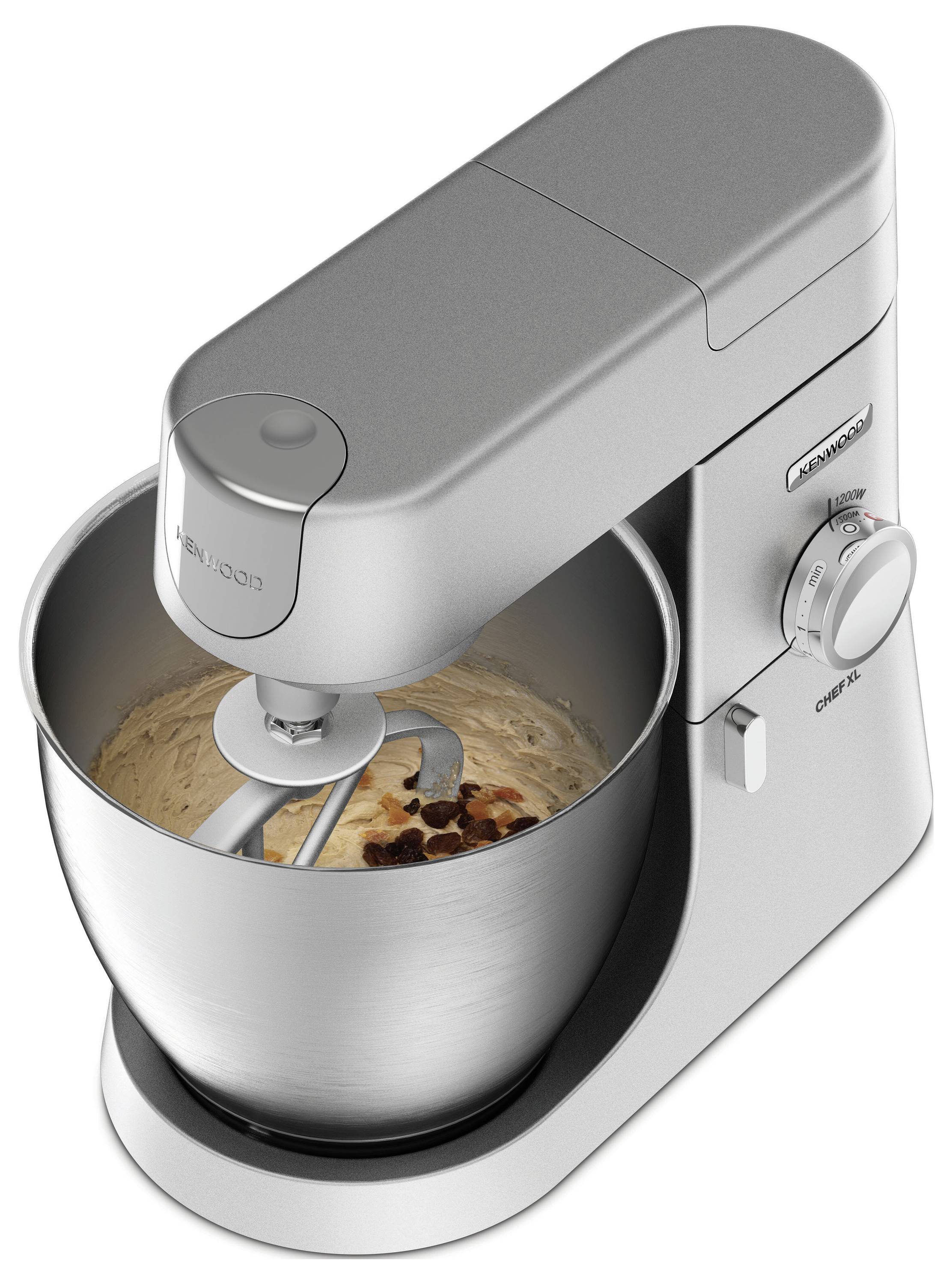 Ein silberner Standmixer verknetet Teig mit Schokoladenchips in einer Metallschüssel. Der Mixer verfügt über ein Einstellungsrad an der Seite.