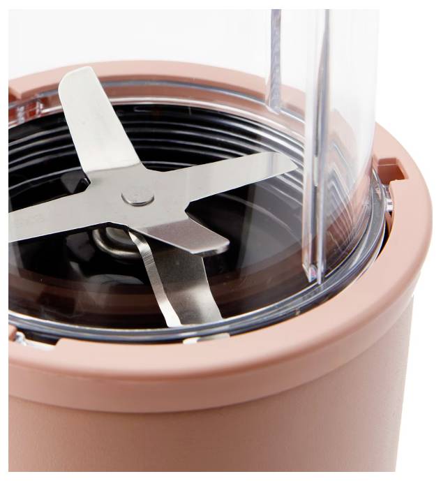 Eine Nahaufnahme eines Mixermessers im Inneren eines rosa Küchengeräts.