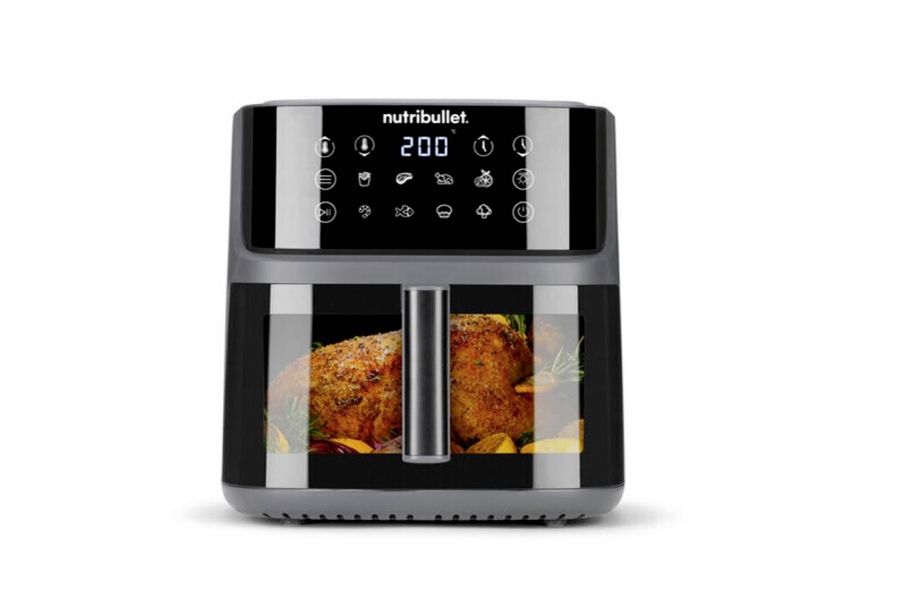 Ein moderner Heißluftfritteuse mit einem digitalen Bedienfeld, das auf 200°C eingestellt ist. Im Inneren ist durch das Glas ein gewürzter Hähnnenbraten mit Gemüse sichtbar.