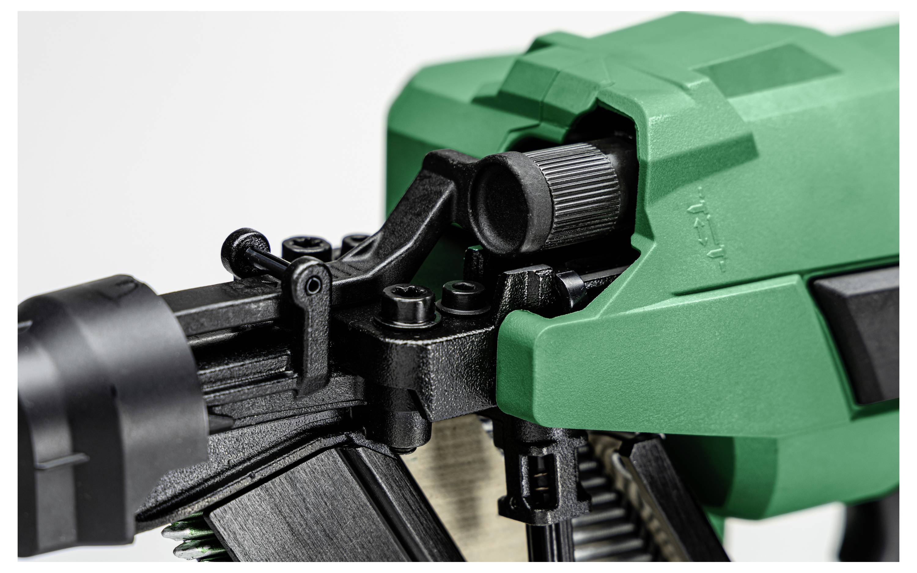 Nahaufnahme eines grünen und schwarzen Naglers, die das Einstellungsrad und den Auslösemechanismus zeigt und seinen Aufbau und seine Funktionalität hervorhebt.