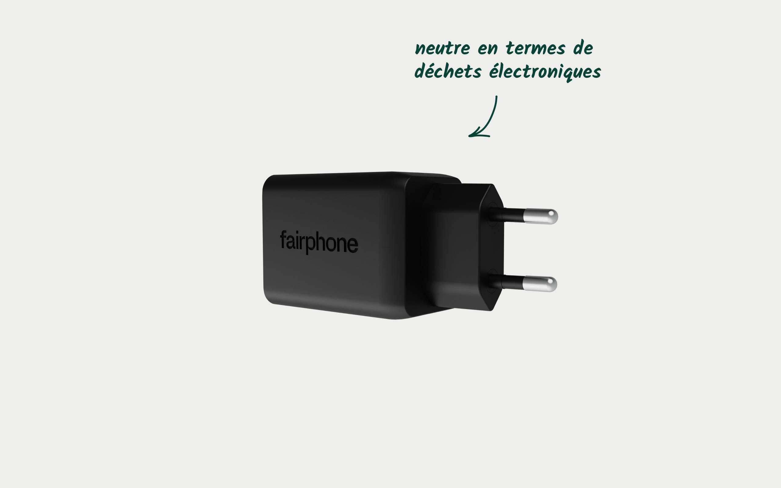 Ein schwarzes Ladegerät mit der Aufschrift 'fairphone'. Ein Pfeil weist auf die Aufschrift 'neutre en termes de déchets électroniques'.