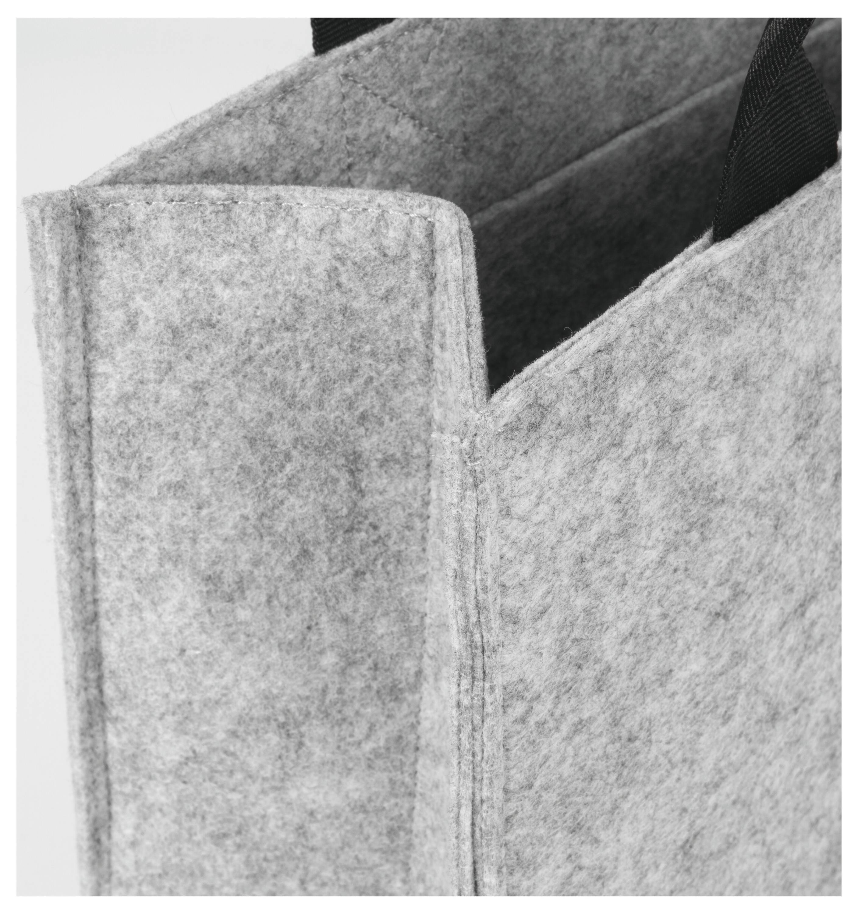 Eine Nahaufnahme einer grauen Filz-Tragetasche mit sichtbarem Henkel, die das strukturierte Material und die robuste Konstruktion hervorhebt.