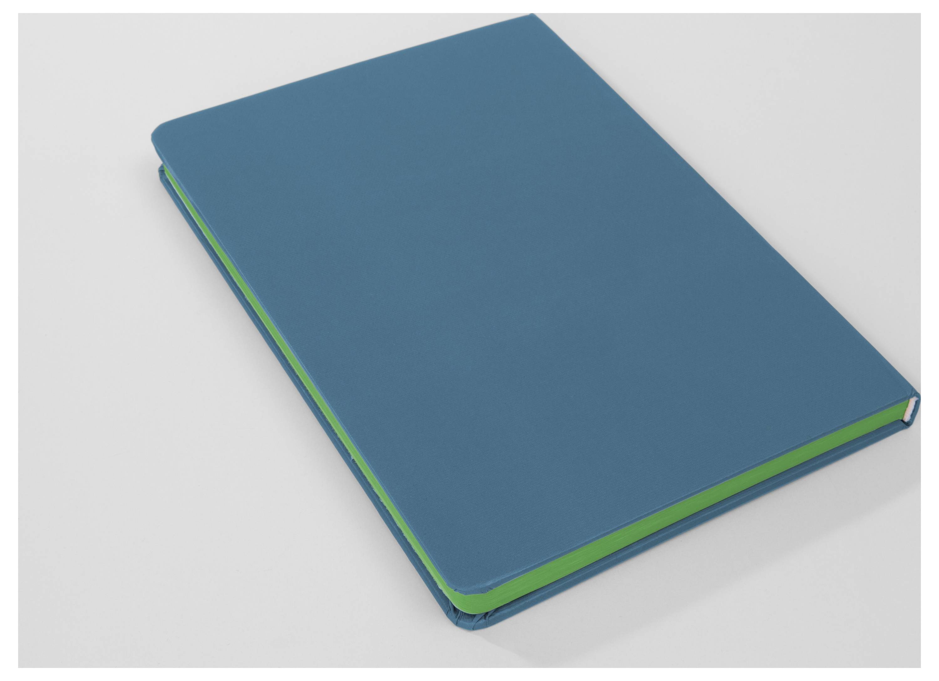 Blaues Hardcover-Notizbuch mit grünen Seitenkanten, geschlossen auf einer hellen Oberfläche liegend.