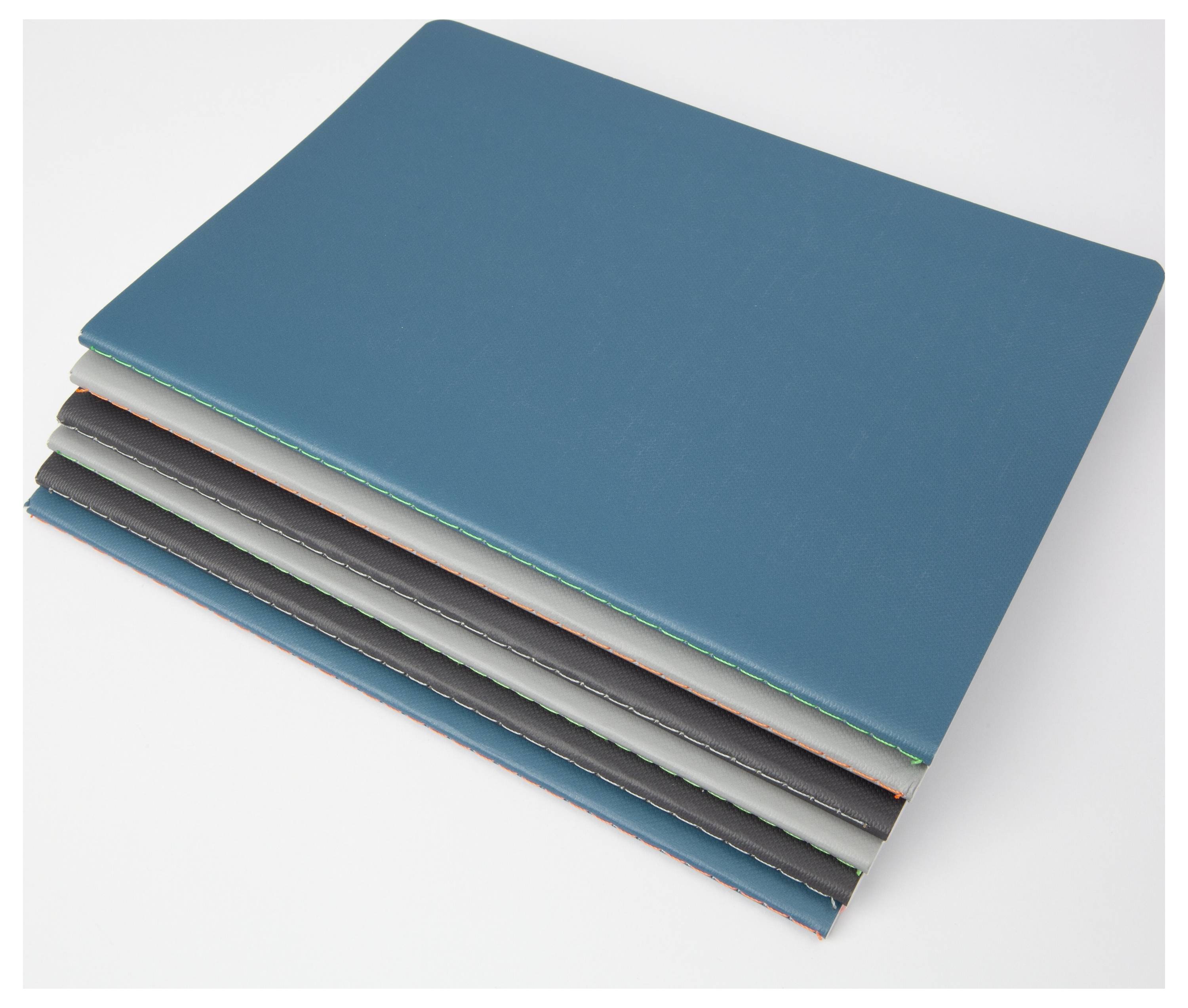 Stapel geschlossener blauer und grauer Notizbücher oder Ordner auf weißem Hintergrund.