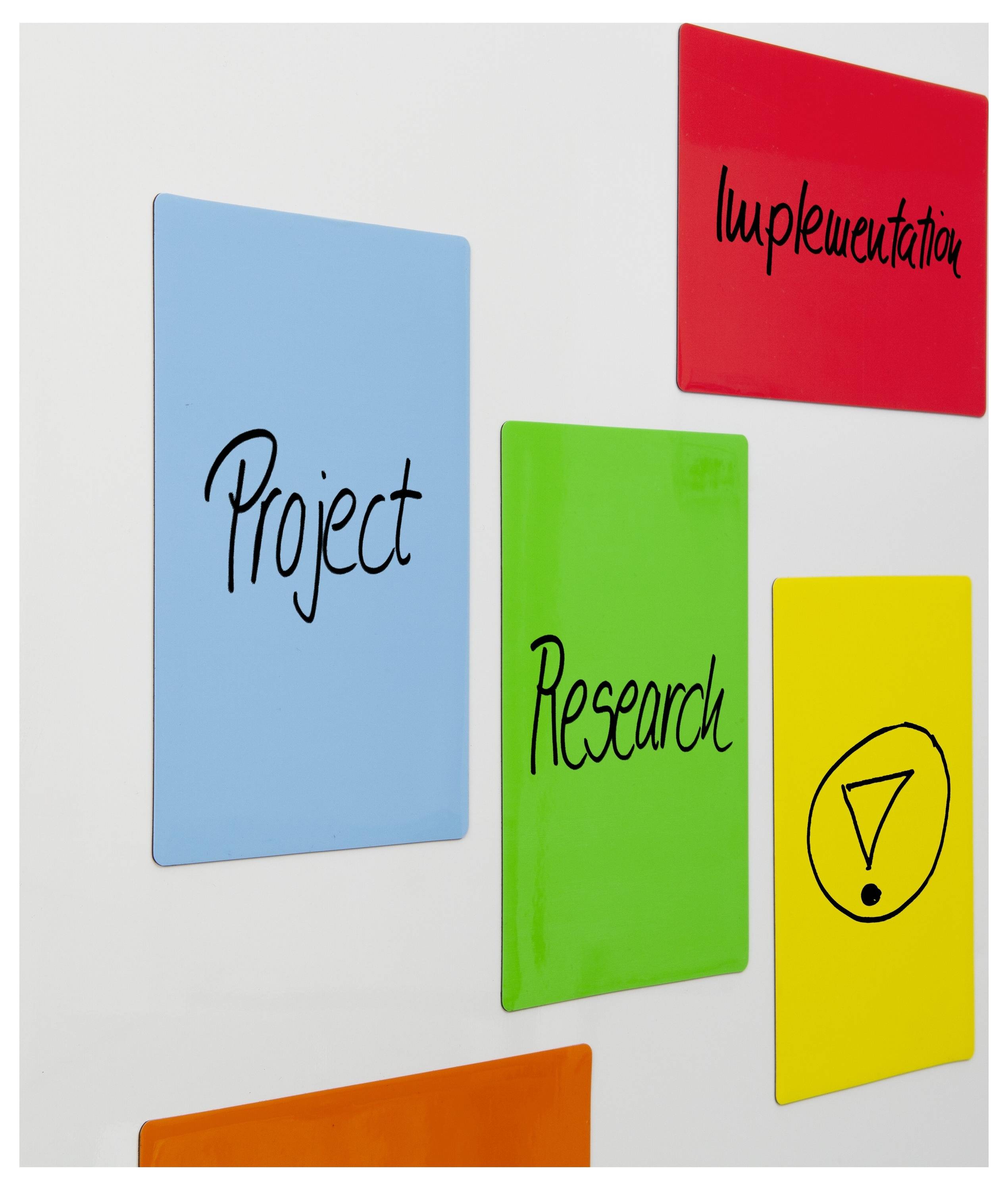 Bunte Haftnotizen an einer Wand mit den Beschriftungen „Projekt", „Forschung" und „Implementierung", mit einer gelben Notiz, auf der ein Dreieck-Symbol zu sehen ist.