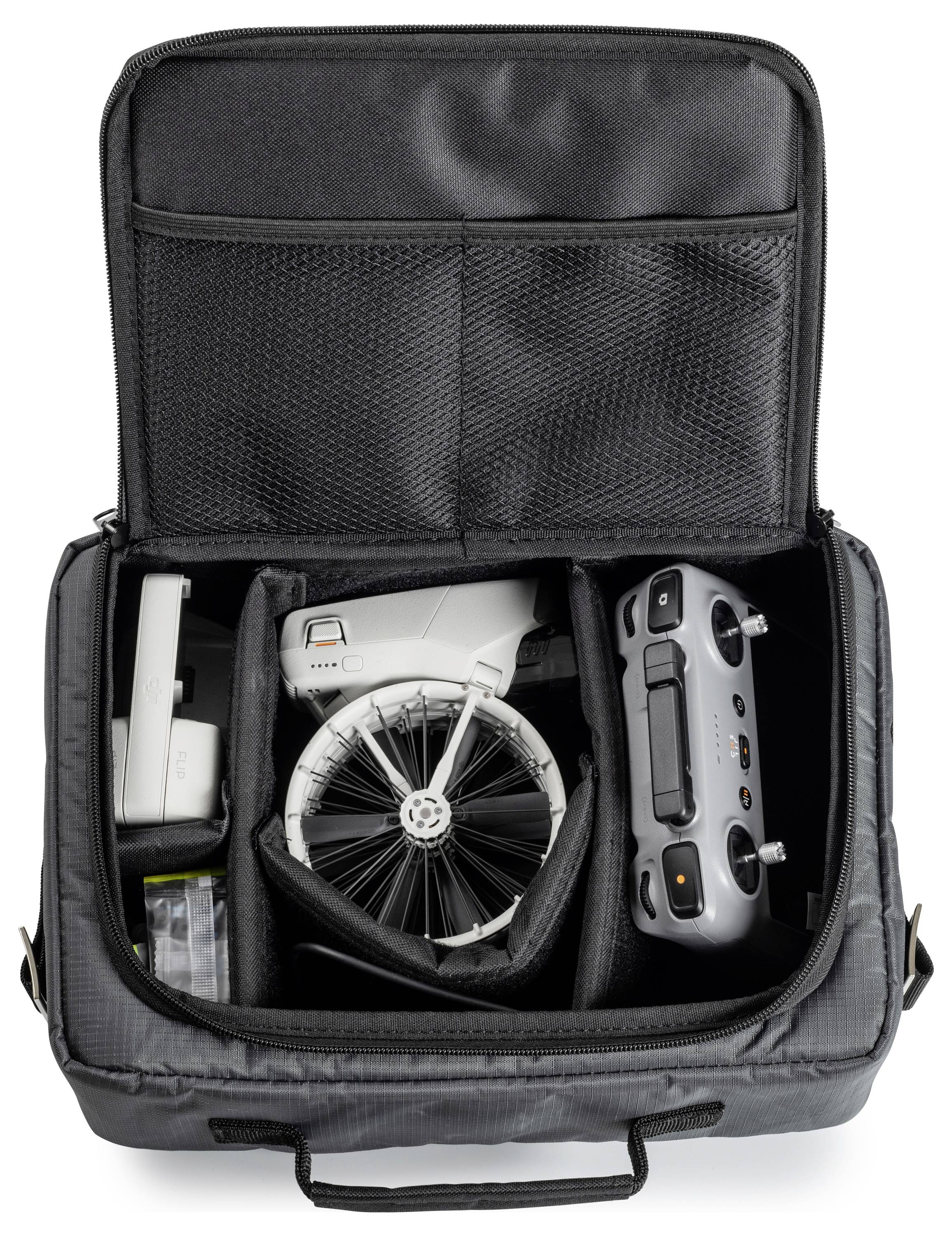 Eine graue Tasche, die eine Drohne, einen Controller und Zubehör enthält, alles sorgfältig in gepolsterten Fächern organisiert, mit geöffnetem Deckel.