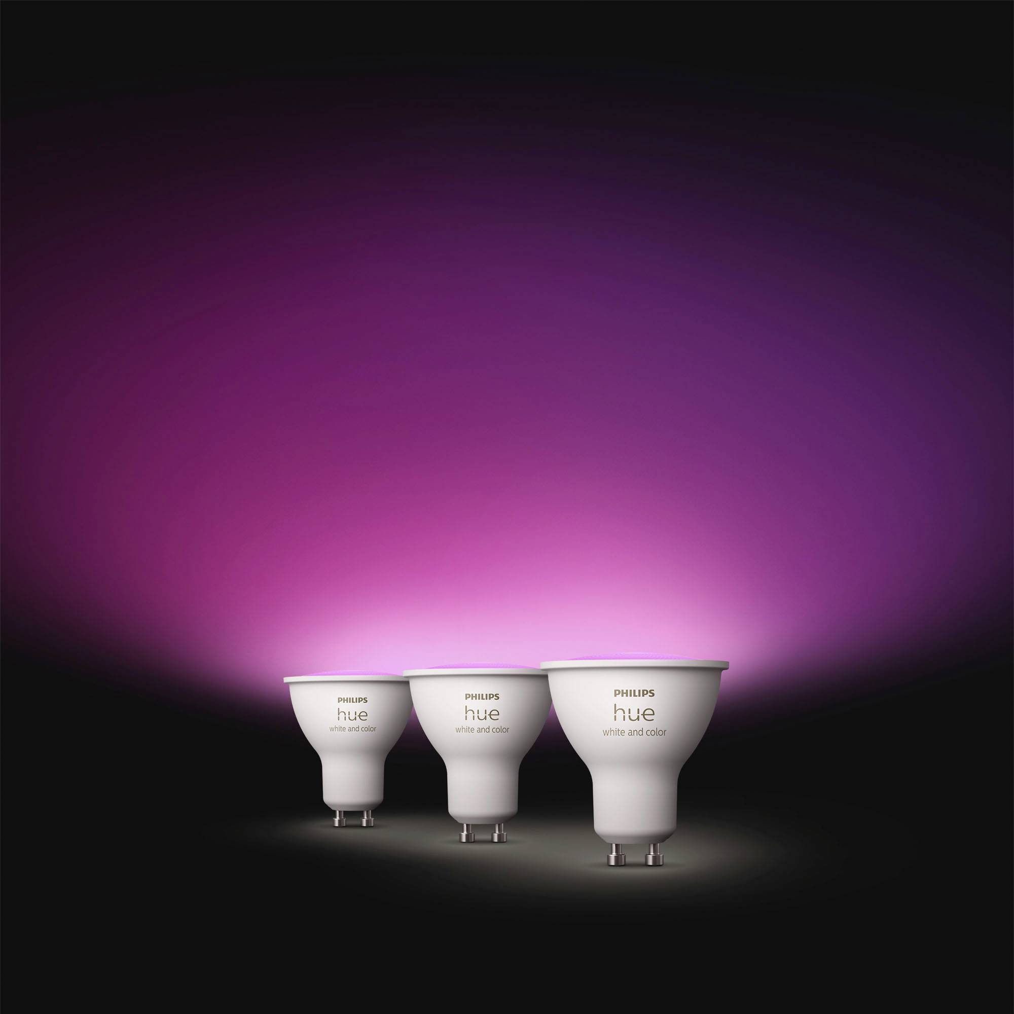 Drei Philips Hue Smart-Glühbirnen werden vor einem leuchtend violetten Hintergrund präsentiert, der ihre Fähigkeit zur Farbwechsel-Beleuchtung hervorhebt.