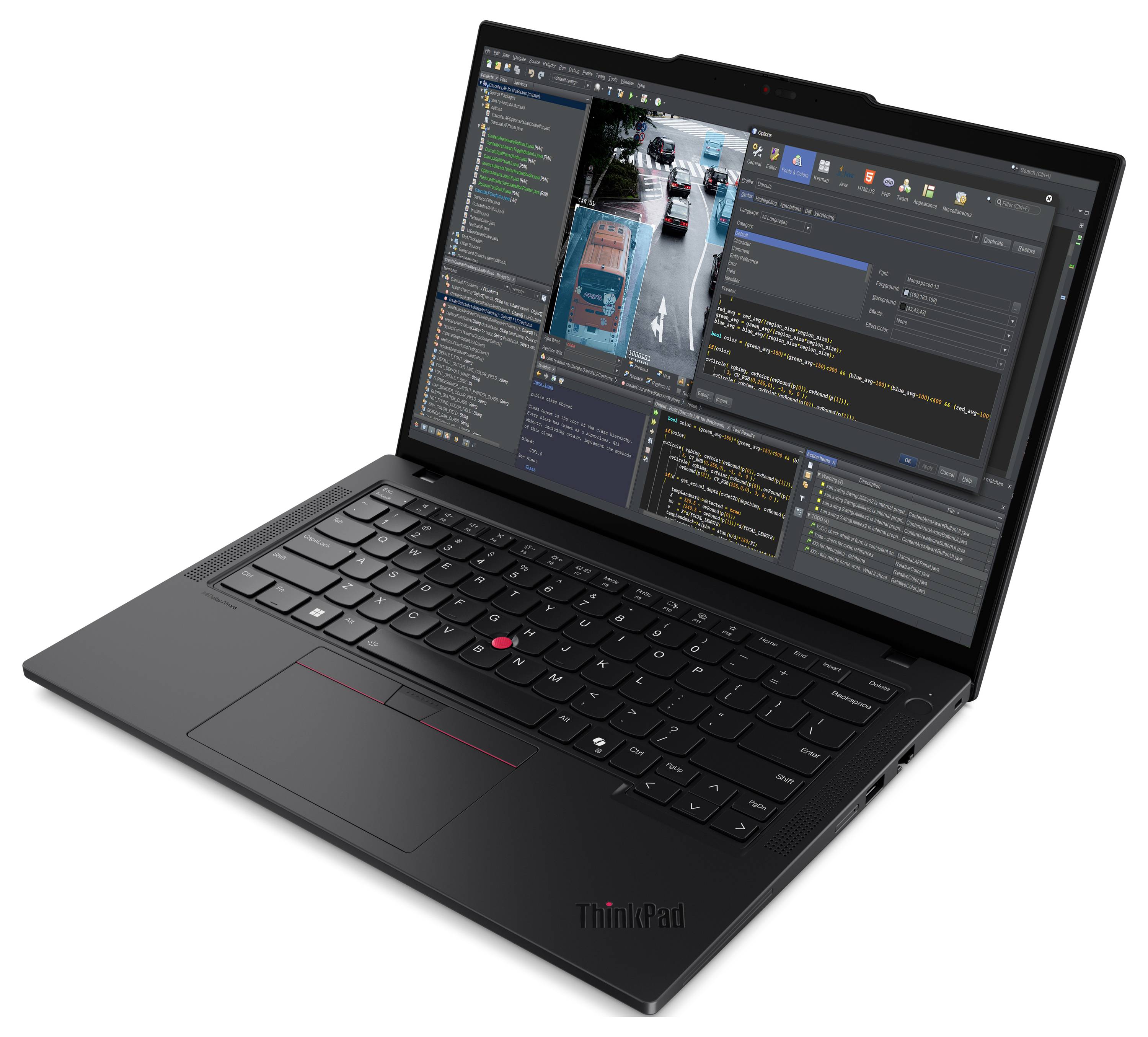 Ein schwarzer Laptop, der eine Softwareentwicklungsumgebung mit Code-Editoren und ein Stadtverkehrsbild zur Simulation zeigt.
