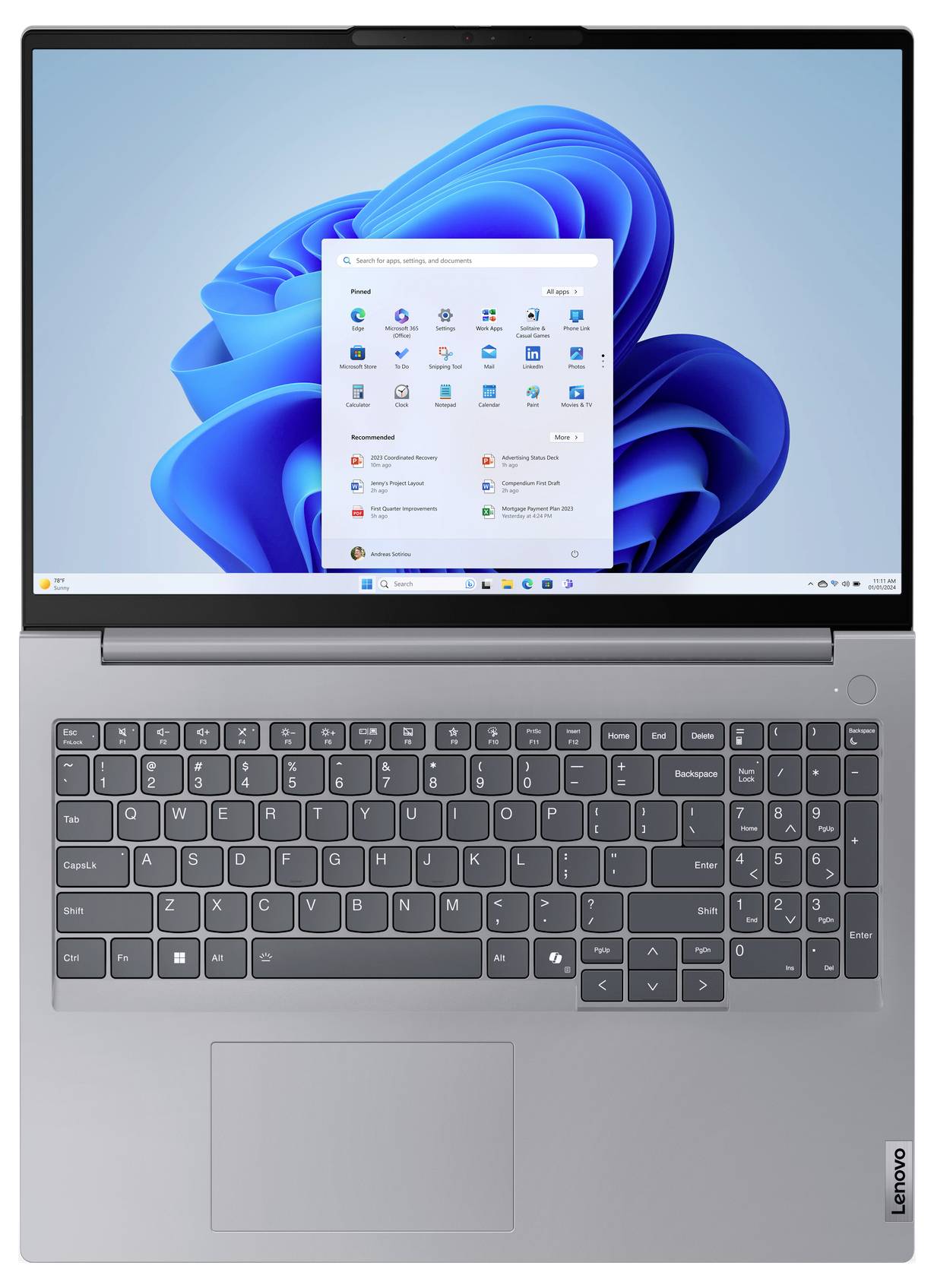 Ein silberner Laptop mit einem Windows 11-Startbildschirm, der Anwendungssymbole und einen blauen abstrakten Hintergrund zeigt.