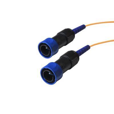 Zwei blaue und schwarze Glasfaserverbinder mit orangefarbenen Kabeln sind nebeneinander angeordnet und werden für Datenübertragungsverbindungen verwendet.
