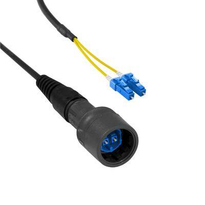 Glasfaserkabel mit schwarzem Stecker und zwei blauen LC-Steckern, die an gelbe Kabel angeschlossen sind, verwendet für Datenübertragung.