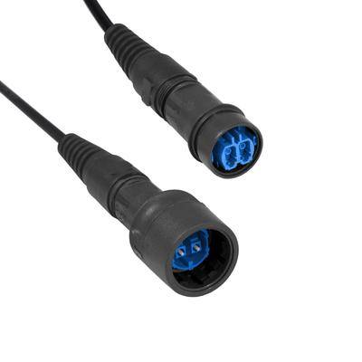 Zwei schwarze Kabel mit runden Anschlüssen, nebeneinander auf einem weißen Hintergrund liegend, wobei das Blau des Inneren der Anschlüsse sichtbar ist.