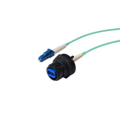 Glasfaserverbinder und -adapter mit blauem Stecker und grünem Kabel, verwendet für hochgeschwindigkeits Datenübertragung in Netzwerkumgebungen.