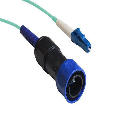 Ein blau-schwarzer Glasfaserverbinder mit einem grünen Kabel und blau-weißer Spitze, verwendet für Hochgeschwindigkeits-Netzwerkverbindungen.