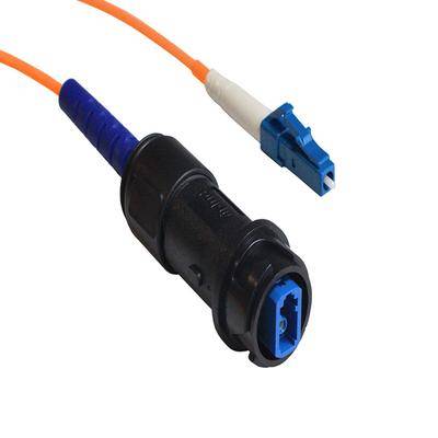 Ein Bild eines Glasfaserkabelsteckers mit einem orangefarbenen Kabel und einer blauen Kunststoffhülse, verwendet für Hochgeschwindigkeits-Internetverbindungen.